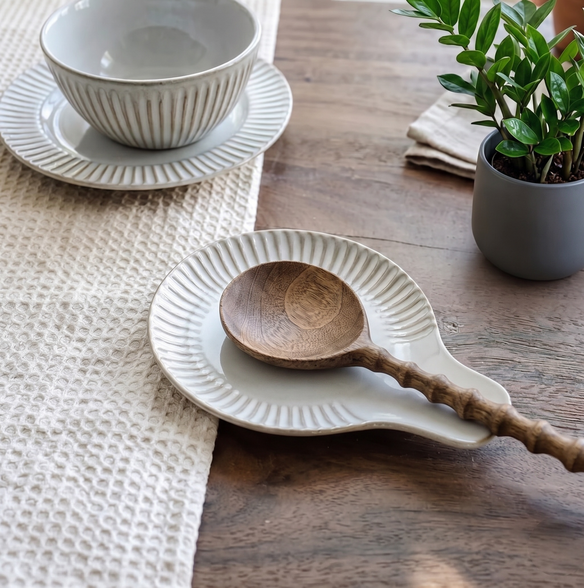 White ceramic spoon rest with a wooden spoon